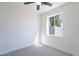Bright bedroom with gray carpet, a ceiling fan, and window with view of backyard at 2991 E Folley Pl, Chandler, AZ 85225
