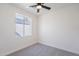 This bedroom is bright with neutral carpet, a ceiling fan, and a window overlooking a small yard at 2991 E Folley Pl, Chandler, AZ 85225