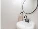 Modern powder room features a round mirror and sleek, wall-mounted sink with matte black fixtures at 2991 E Folley Pl, Chandler, AZ 85225