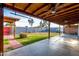 Covered patio has ceiling fans, offering cool respite with a view of the grassy, fenced backyard at 3021 E Larkspur Dr, Phoenix, AZ 85032