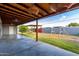 A covered patio is shown with modern hanging lights and a ceiling fan overlooking a well-kept backyard at 3021 E Larkspur Dr, Phoenix, AZ 85032