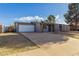 Single story grey home with front lawn and long driveway to attached garage at 3021 E Larkspur Dr, Phoenix, AZ 85032