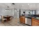 Functional kitchen with tile floors, wooden cabinets, and dining area at 3021 E Larkspur Dr, Phoenix, AZ 85032