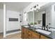 Bathroom featuring a double sink vanity with black countertop and walk-in shower with marble surround at 3022 E Emile Zola Ave, Phoenix, AZ 85032