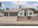 Charming single-story home featuring a three-car garage and arched entryway in a desert landscaped front yard at 3022 E Emile Zola Ave, Phoenix, AZ 85032