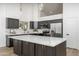 Modern kitchen featuring an island with a white countertop and dark cabinets plus stainless steel appliances at 3022 E Emile Zola Ave, Phoenix, AZ 85032