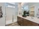Modern bathroom featuring double sinks, wood cabinets, and a glass-enclosed shower with marble-style walls and bench seating at 3141 S 155Th Ln, Goodyear, AZ 85338