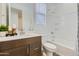 Bright, tidy bathroom featuring wood vanity with a modern sink, a clean toilet, and a bathtub with a shower at 3141 S 155Th Ln, Goodyear, AZ 85338