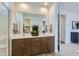 Stylish bathroom showcasing double vanity with warm wood cabinetry, quartz countertop, and large mirror reflecting ample space at 3141 S 155Th Ln, Goodyear, AZ 85338