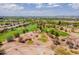 Expansive aerial view of lush golf course community under a sunny sky with mature trees and distant city view at 3252 E Maldonado Dr, Phoenix, AZ 85042