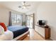 Bright bedroom featuring wood floors, ceiling fan, and sliding glass door to outdoor space at 3252 E Maldonado Dr, Phoenix, AZ 85042