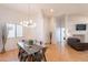 Dining area with a glass-topped table, six chairs, and modern light fixture at 3252 E Maldonado Dr, Phoenix, AZ 85042