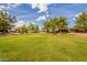 Large grassy area featuring mature trees, desert landscaping, and a community walking path at 3252 E Maldonado Dr, Phoenix, AZ 85042