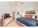 A well-lit main bedroom with wooden floors, a ceiling fan, and a console at 3252 E Maldonado Dr, Phoenix, AZ 85042