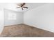 A bright bedroom features a ceiling fan and a window that provides plenty of natural light at 4133 E Pleasant Ln, Phoenix, AZ 85042