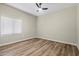 A bright bedroom with wood floors, ceiling fan, and a window letting in natural light at 5127 W Willow Ave, Glendale, AZ 85304