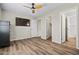 Spacious main bedroom featuring wood-look floors, a ceiling fan and a wall-mounted TV at 5127 W Willow Ave, Glendale, AZ 85304