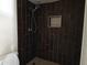 Dark wood tile shower featuring a shower head and built-in shelving at 6226 W Coronado Rd, Phoenix, AZ 85035