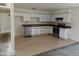 A well-lit kitchen with white cabinetry, stainless steel appliances, and tile flooring at 6226 W Coronado Rd, Phoenix, AZ 85035