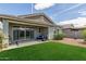 Backyard patio with seating area and a green lawn, perfect for outdoor entertaining and relaxation at 686 N 152Nd Dr, Goodyear, AZ 85338