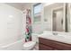 Bright bathroom featuring a shower-tub combo with decorative shower curtain and a single sink vanity at 686 N 152Nd Dr, Goodyear, AZ 85338