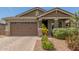 Charming home exterior featuring a two-car garage, brick accents, and desert landscaping at 686 N 152Nd Dr, Goodyear, AZ 85338