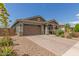 Charming single-story home with brick driveway, desert landscaping, and a two-car garage at 686 N 152Nd Dr, Goodyear, AZ 85338