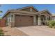 Inviting home featuring a two-car garage and a charming covered entryway with stone-accented columns at 686 N 152Nd Dr, Goodyear, AZ 85338