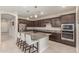 Gourmet kitchen with stainless steel appliances, granite countertops, a large island, and dark wood cabinetry at 686 N 152Nd Dr, Goodyear, AZ 85338
