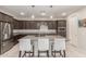 Modern kitchen featuring granite countertops, dark cabinets, stainless steel appliances, and an island with seating at 686 N 152Nd Dr, Goodyear, AZ 85338