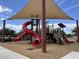 Community playground with a bright red slide and shaded area for Gathering-friendly fun at 686 N 152Nd Dr, Goodyear, AZ 85338