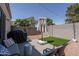 Cozy backyard featuring artificial turf, seating area, and grill, perfect for outdoor entertaining at 7028 W Lincoln St, Peoria, AZ 85345