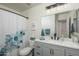 Bright bathroom featuring a gray vanity, updated lighting and bath with a shower curtain at 7028 W Lincoln St, Peoria, AZ 85345