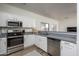 This kitchen features stainless steel appliances, modern cabinetry, and laminate flooring at 7028 W Lincoln St, Peoria, AZ 85345