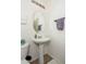 Clean powder room featuring pedestal sink, oval mirror, and stylish decor for a modern look at 7028 W Lincoln St, Peoria, AZ 85345