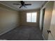 Cozy bedroom featuring neutral walls, carpet, a ceiling fan, and a bright window at 7240 W Los Gatos Dr, Glendale, AZ 85310