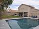 Backyard featuring a large pool, covered patio with seating, and grassy area at 7240 W Los Gatos Dr, Glendale, AZ 85310