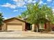 Charming single-story home featuring a two-car garage, desert landscaping, and a mature shade tree in the front yard at 7310 W Pioneer St, Phoenix, AZ 85043