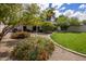 Charming backyard with a manicured lawn, mature trees, and flowering bushes. Perfect for outdoor entertaining at 7608 E Avalon Dr, Scottsdale, AZ 85251