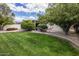 Relax in this lush backyard featuring a pristine lawn and comfortable hammock shaded by mature trees at 7608 E Avalon Dr, Scottsdale, AZ 85251