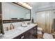 Bathroom highlighting a double vanity with marble countertops, gold faucets, and decorative mirror at 7608 E Avalon Dr, Scottsdale, AZ 85251