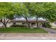 Charming single-story home with mature shade trees, green door, and covered carport at 7608 E Avalon Dr, Scottsdale, AZ 85251