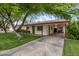 Single-story home featuring a well-manicured lawn, covered carport, and a welcoming green front door at 7608 E Avalon Dr, Scottsdale, AZ 85251