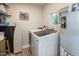 Functional laundry room featuring a washer and dryer, storage shelves, and water heater at 7608 E Avalon Dr, Scottsdale, AZ 85251