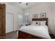 Cozy bedroom with a dark wood bed frame, white bedding, and bright windows with shutters at 7848 E Parkview Ln, Scottsdale, AZ 85255