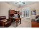 Comfortable home office with desk, built-in shelves, and bright window with shutters at 7848 E Parkview Ln, Scottsdale, AZ 85255