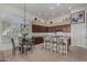 Bright kitchen with dark wood cabinets, granite countertops, island with seating, and breakfast table at 7848 E Parkview Ln, Scottsdale, AZ 85255