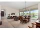 Spacious living room and dining area featuring neutral carpeting, large windows, and elegant chandelier lighting at 7848 E Parkview Ln, Scottsdale, AZ 85255