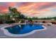 Inviting swimming pool featuring rock accents, a waterfall, and elegant tile surround set in a private backyard oasis at 7848 E Parkview Ln, Scottsdale, AZ 85255
