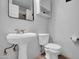 Compact bathroom featuring a pedestal sink, toilet, and classic neutral tones at 7977 W Wacker Rd # 134, Peoria, AZ 85381